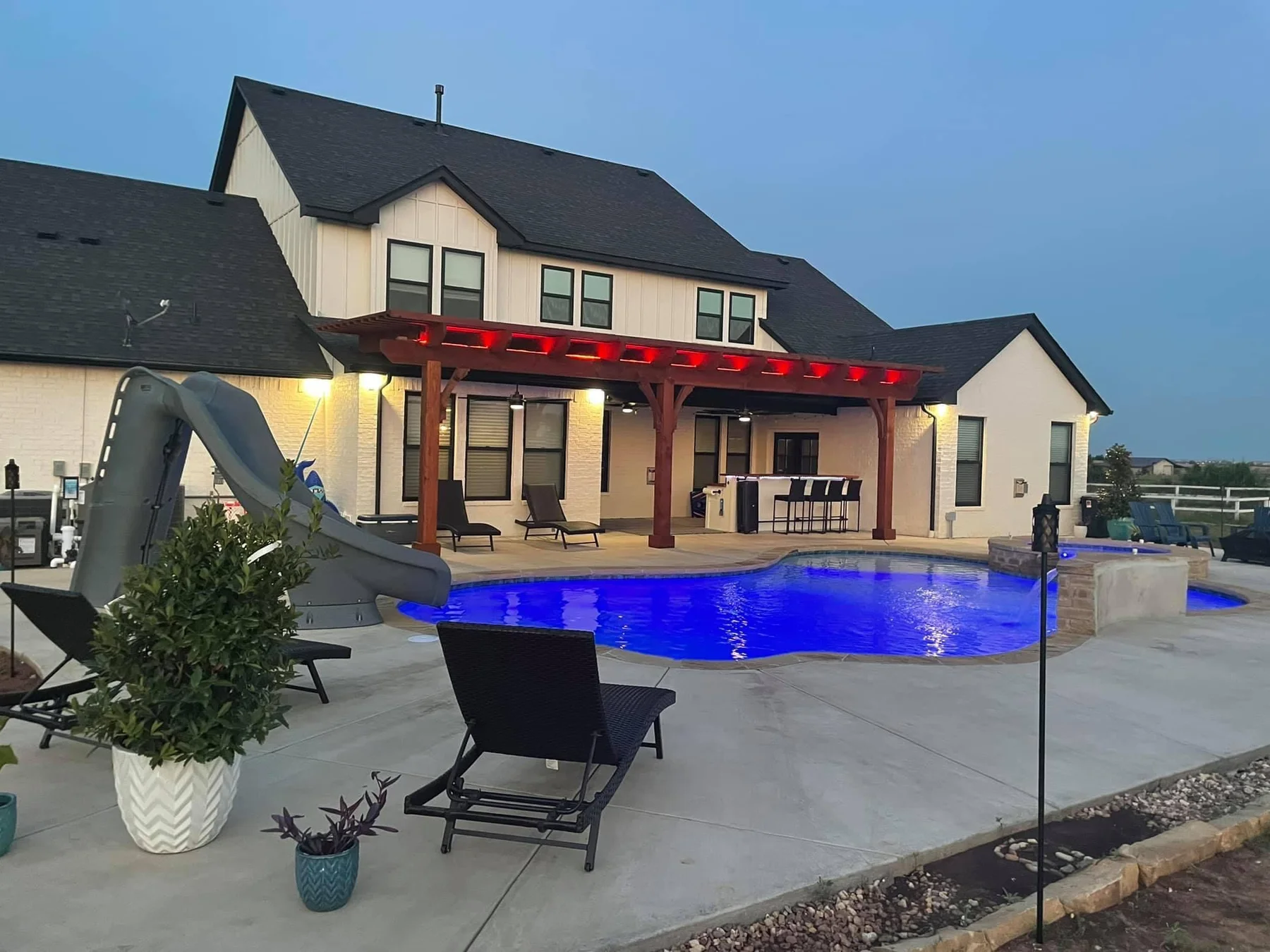 Red LED lighting on custom pergola at night with pool — Pergola Jack OKC