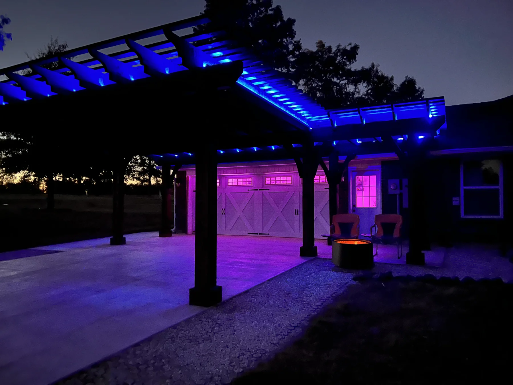 Blue and purple dual-color LED lighting on attached pergola at night