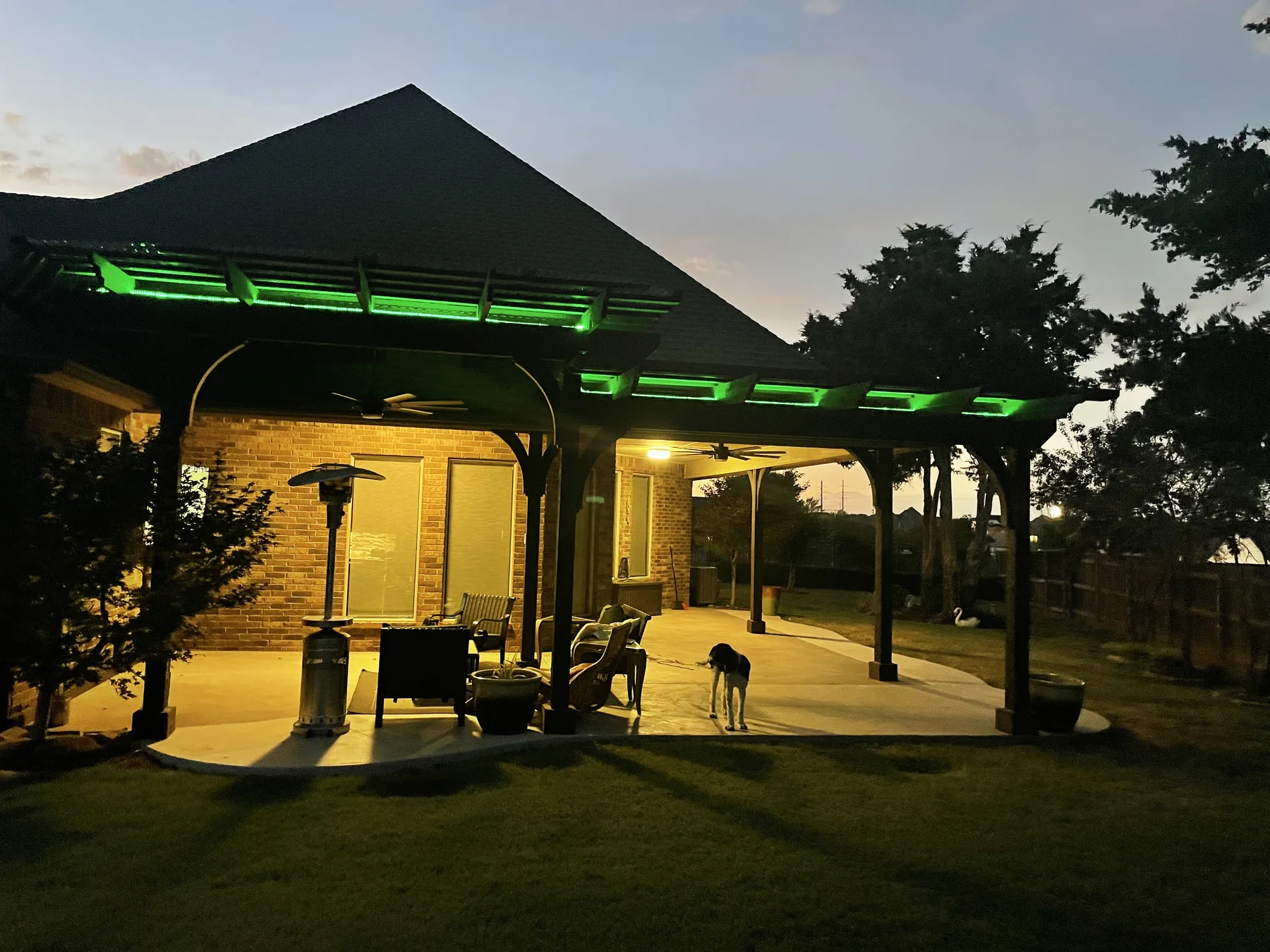 Green LED lighting on large double-bay pergola at dusk — Pergola Jack